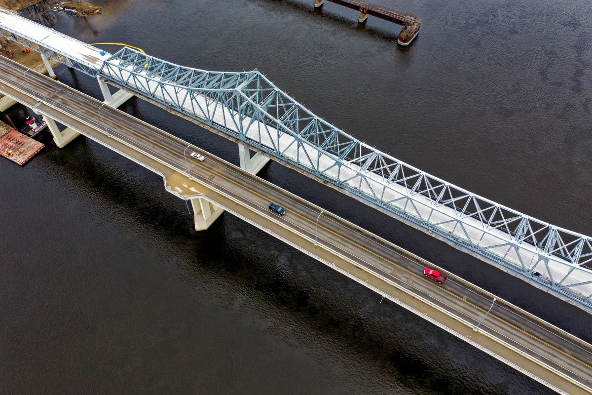 Aerial view of cars crossing a long steel bridge over the Mississippi River.