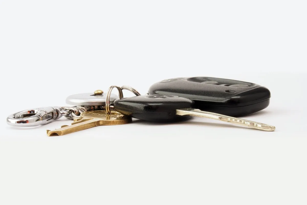 A set of car keys with a key fob resting on a white counter.